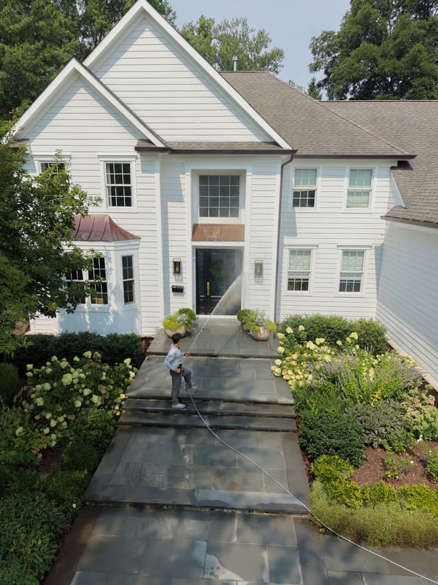 Drone view of a front walkway being pressure washed