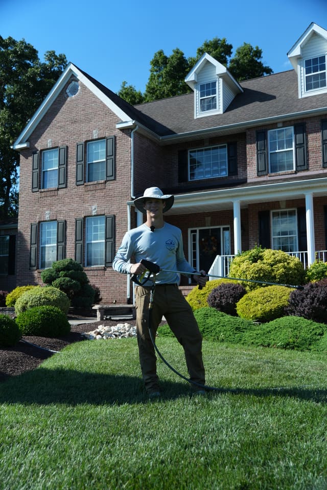 Soft washing the front of a brick colonial home in Bucks County